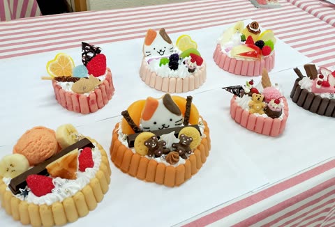 Decorated cakes arranged on a striped tablecloth.