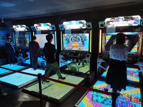 People playing DanceRush arcade game on illuminated dance pads.
