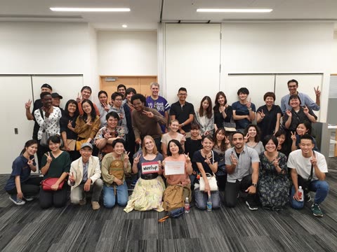 Large group posing for photo in a room.